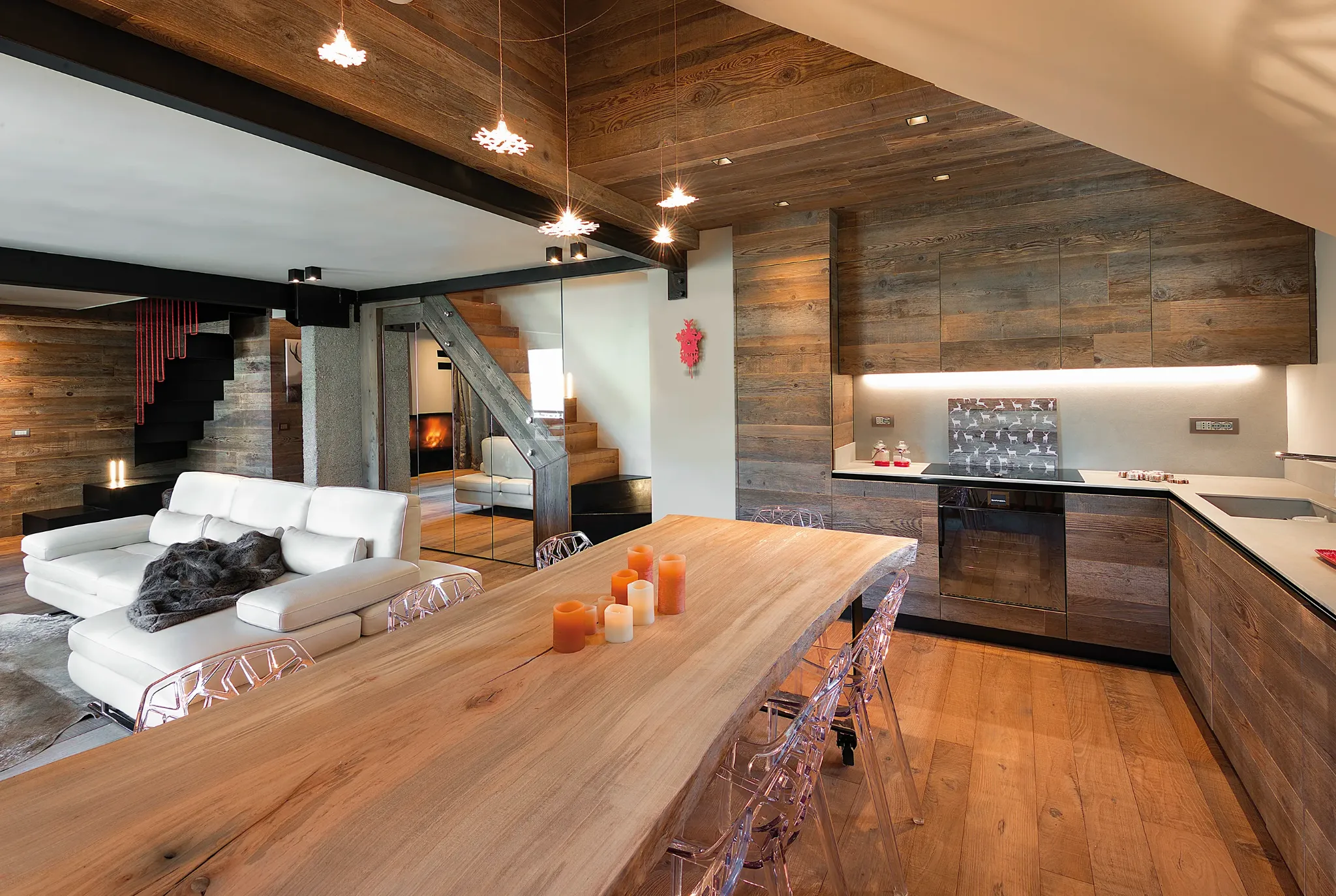 Ambiente completo con scala, cucina e tavolo ricavato da una grande tavola di legno